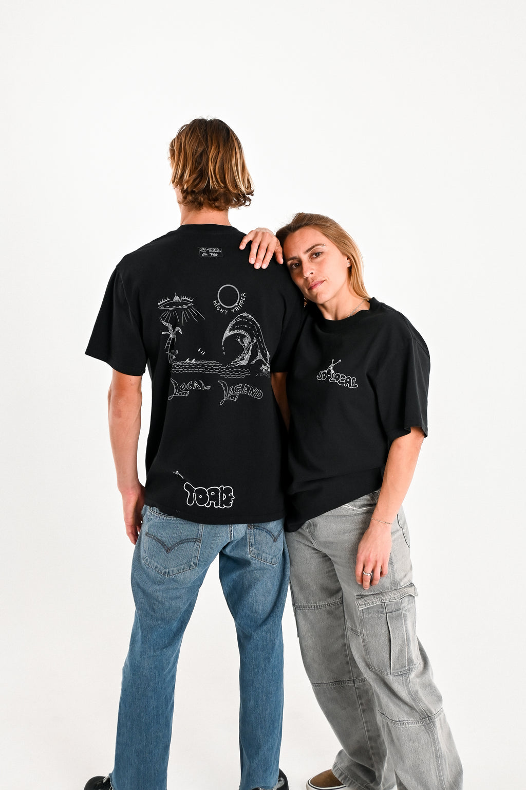 Male and female model wearing NIGHT TRIPPER "Local Legend" heavy faded t-shirt in black, surf and skate streetwear, studio shot, Gold Coast Australia  