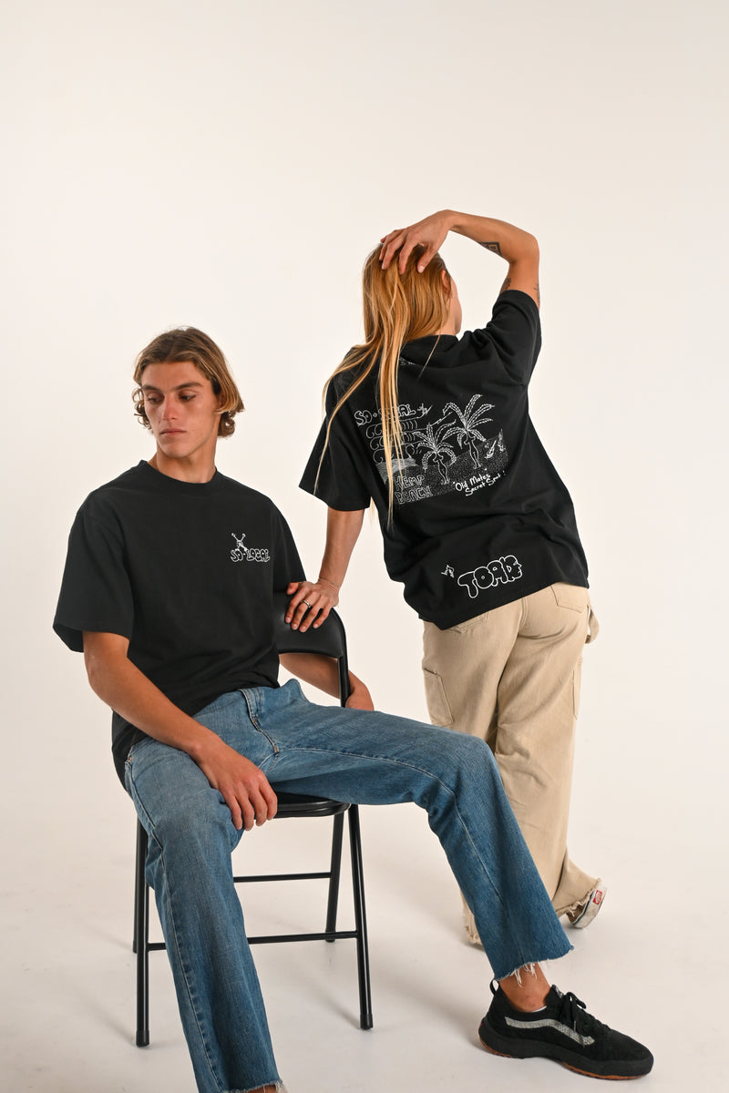 Male and female models wearing OLD MATES SECRET SPOT (Hemp Beach) heavy faded t-shirt in black, surf and skate streetwear, studio shot, Gold Coast Australia 