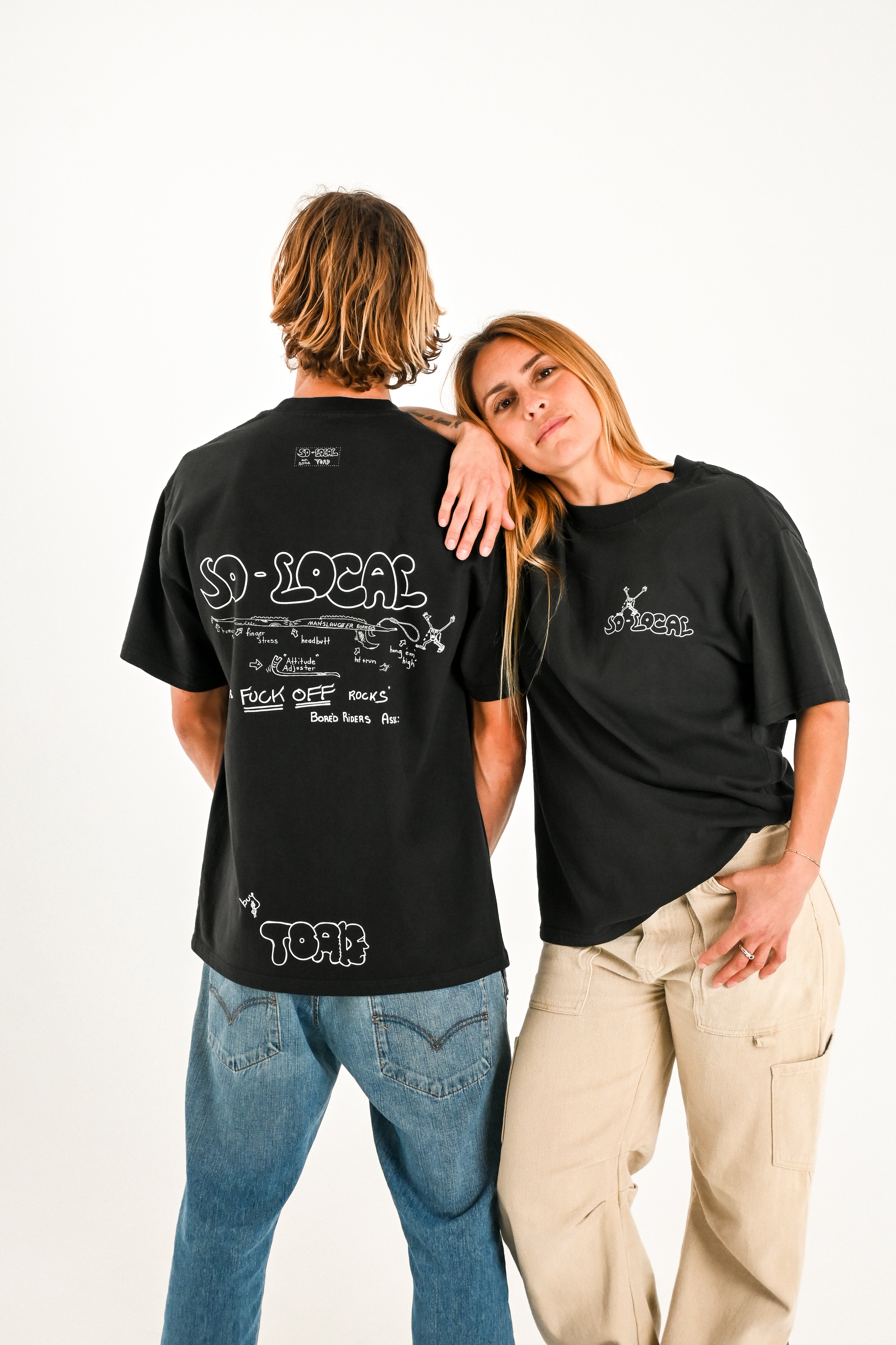 Male and female models wearing SNAPPER F*CK OFF ROCKS heavy faded t-shirt in black, surf and skate streetwear, studio shot, Gold Coast Australia 